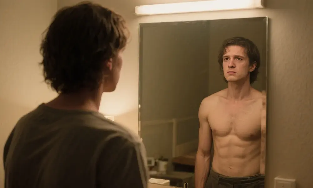 A person looking at their reflection in a mirror, with the reflection showing a stronger, more confident version of themselves.