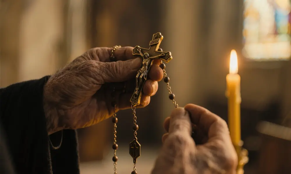 Cinematic scene of hands holding rosary and crucifix with warm candlelight representing spiritual protection